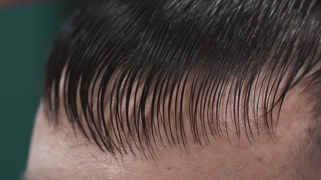 Hairdresser cutting hair of man in Barbershop