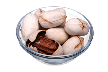 Pecan nuts in glass cup isolated on white background