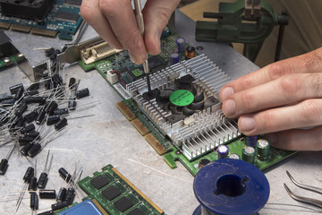 Naprawa karty graficznej. Odkręcanie wiatraczka chłodzącego. Usługa serwisowa w serwisie  komputerowym. Pracownik w serwisie elektrycznym podczas pracy. © Tomasz