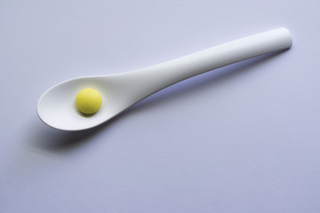 spoon with yellow pill