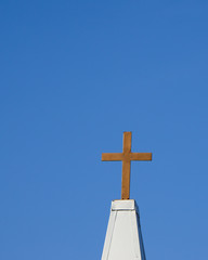 Gold metal cross against a deep blue background