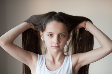 Fototapeta premium beautiful little girl lifting up her hair by hands