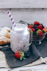 Fresh milk, strawberry, blueberry and banana drinks on wodeen table, assorted protein cocktails with fruits