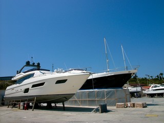 Luxusyachten in Weiß und Schwarz vor blauem Himmel im Sonnenschein im Trockendock am Hafen von...