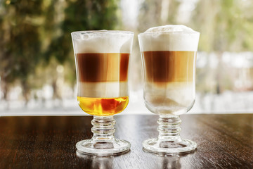 Two glasses of latte coffee table by the window