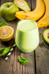 Healthy food. Dietary breakfast or snack. Green smoothies from yoghurt, avocado, banana, apple, spinach and lemon. On a rustic wooden table, with ingredients. Copy space 