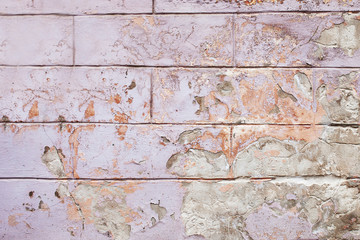 Old cracked wall background, the lilac and orange paint texture is chipping