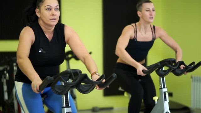 Women are actively engaged in group bike training to maintain physical fitness. Cicle training is a good cardio load on the body of athletes before the upcoming physical exercises.