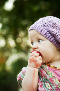 Child with strawberry in nature