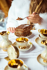 Front view of little beautiful girl's hands holding a piece of cake on a spoon in the park