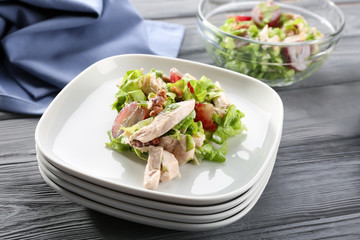 Plates with chicken salad and grapes on table