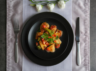 Plate of chicken stir fry with vegetables on table