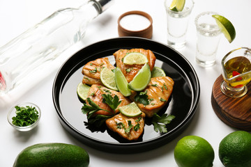 Plate of delicious tequila lime chicken with ingredients on white background