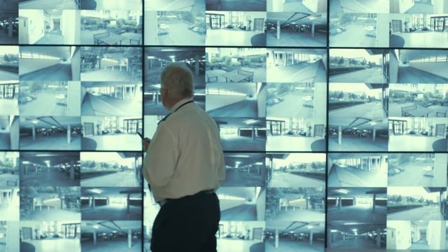  Security & surveillance team working in system control room. Could be a meteorological weather station or airport traffic control room. 