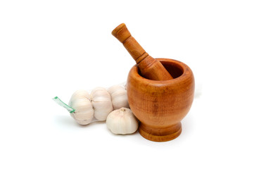 pile of garlic with a clay mortar and pestle isolated on white background