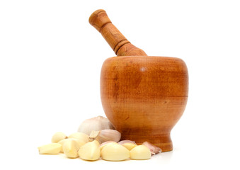 pile of garlic with a clay mortar and pestle isolated on white background