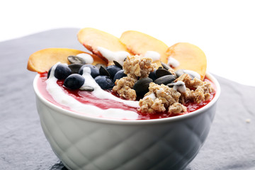 breakfast smoothie bowl with blueberries, peach and granola