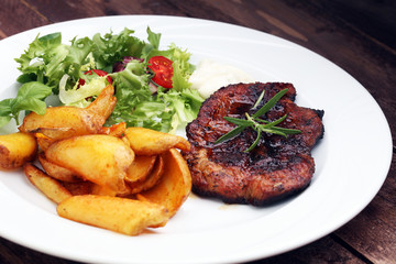 Grilled steaks, baked potatoes and salad