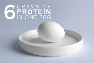 Raw egg on plate on white background