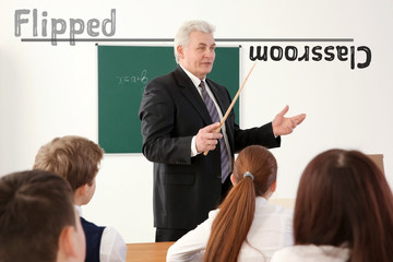 Flipped classroom concept. Senior teacher with children at lesson