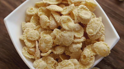 Fresh yellow corn flakes in white bowl