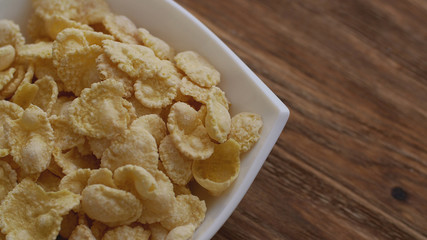 Corn flakes in white bowl with copyspace to the right