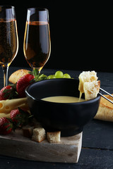 Gourmet Swiss fondue dinner with assorted cheeses on a board and