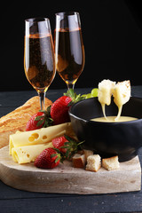 Gourmet Swiss fondue dinner with assorted cheeses on a board and