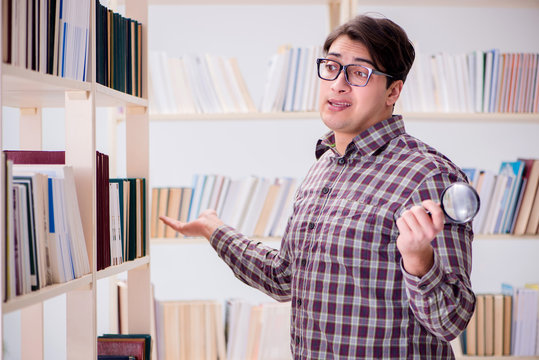 Young student looking for books in college library