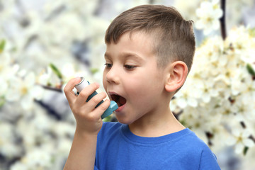 Little boy using asthma inhaler outdoor