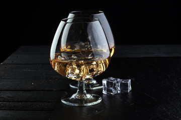 glass of whiskey with ice on a wooden