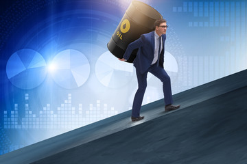 Businessman under the burden of oil barrel