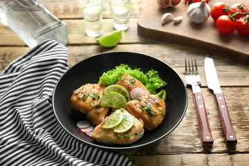 Plate of delicious tequila lime chicken on wooden background
