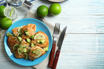 Plate of delicious tequila lime chicken with ingredients on wooden background