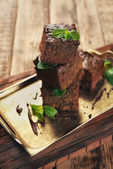 Metal tray with delicious cocoa brownies on wooden table