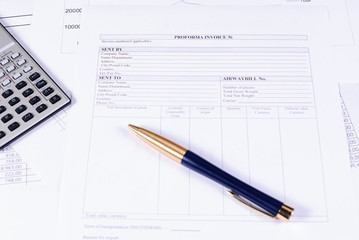 Invoice, calculator and pen on the table