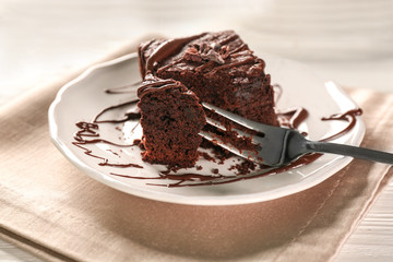 Plate with delicious cocoa brownie on table