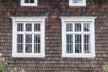 Windows of an old wooden house in Puerto Varas, Chile