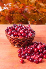 Cranberries in a basket on a wooden background