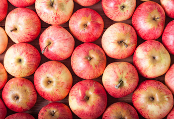 Rows of red apples on a wooden surface. Top View
