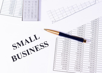 Desk with a calculator, pen and financial tables