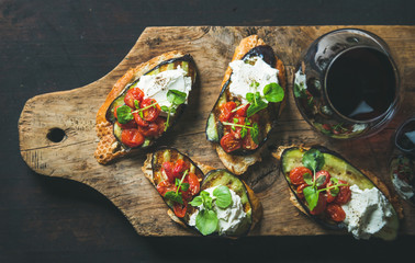 Wine and snack set. Brushetta with grilled eggplant, cherry tomatoes, garlic, cream cheese, arugula...