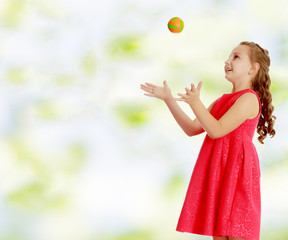 The little girl throws the ball up