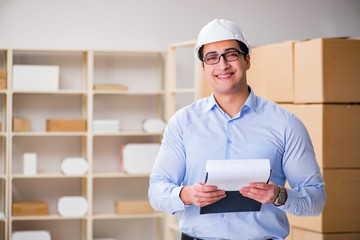 Young worker in the postal office dealing with parcels