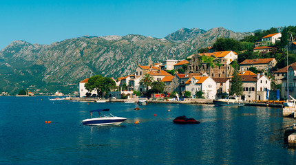 Fototapeta na wymiar The old town of Perast on the shore of Kotor Bay, Montenegro. The ancient architecture of the Adriatic and the Balkans. Boats and yachts on the dock.