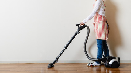 部屋の掃除をするアジア人女性 © beeboys