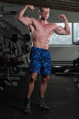 Fototapeta na wymiar Bodybuilder Fitness Model Posing Double Biceps After Exercises