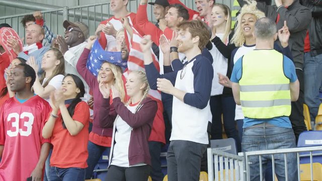  Excited fans with US flag in sports crowd, clapping & cheering on their team
