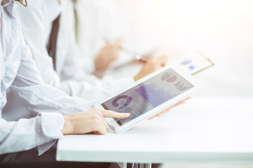 business team using digital tablet performs analysis of marketing graphics