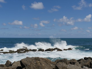 great waves against rocks  white foaming waves crash against rocks creating huge showers